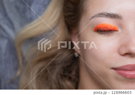 Caucasian woman undergoing eyelash lamination procedure. Top view.  128966603
