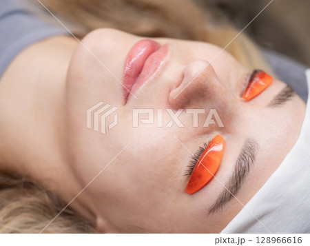 Caucasian woman undergoing eyelash lamination procedure. Caucasian woman undergoing eyelash lamination procedure. 128966616