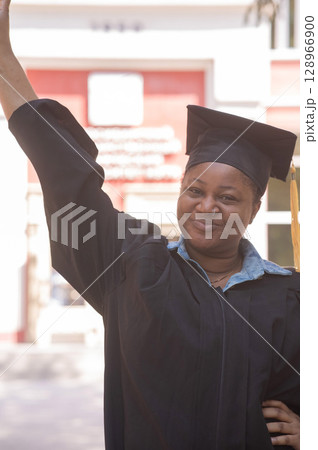 Portrait of happy african woman in graduation gown.  128966900
