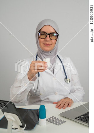 Female doctor in hijab recommends medications.  128966935