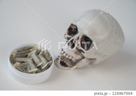 Skull Chewing Tobacco on a White Table. 128967004