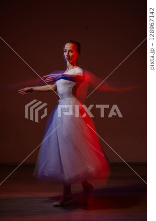 Caucasian woman dancing classical dance in tutu . Long exposure photo. Caucasian woman dancing classical dance in tutu . Long exposure photo. 128967142