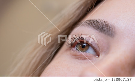 Close-up of a woman's eye after eyelash lamination procedure.  128967157