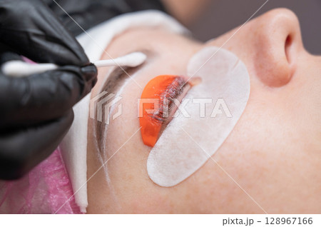 The process of professional lamination and tinting of eyelashes in the salon. The process of professional lamination and tinting of eyelashes in the salon. 128967166