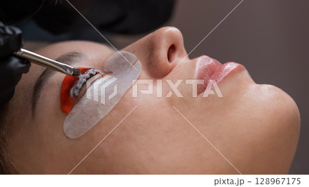 Caucasian woman undergoing eyelash lamination procedure.  128967175