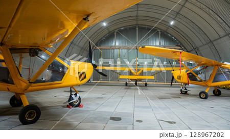 Yellow airplane glider in the hangar. Yellow airplane glider in the hangar. 128967202
