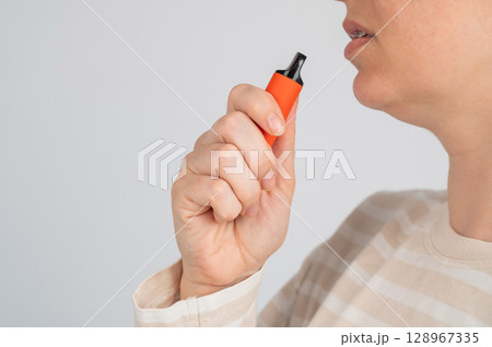 Caucasian woman smoking disposable vape. Caucasian woman smoking disposable vape. 128967335