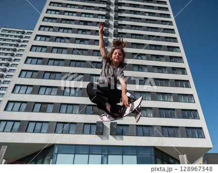 Girl practices skiing tricks on a trampoline.  128967348