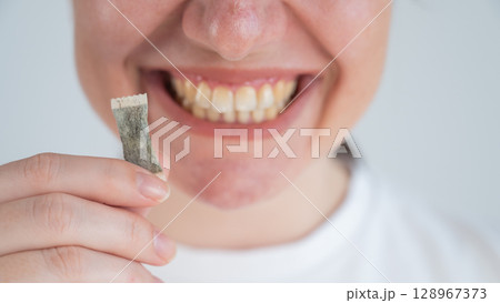 Woman Chewing Nicotine Snus Product.  128967373