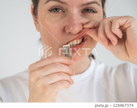 Woman Chewing Nicotine Snus Product.  128967374