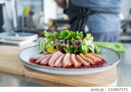 The chef serves roast duck.  128967573