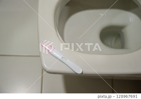 Pregnancy test on the toilet. Pregnancy test on the toilet. 128967691