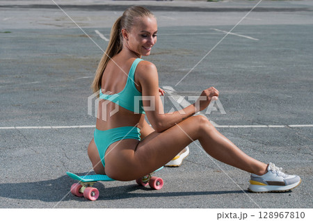Caucasian woman in a swimsuit with a penny board. Caucasian woman in a swimsuit with a penny board. 128967810