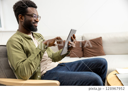 Young man having a video call and looking excited and involved 128967952