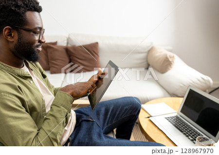 Young man having a video call and looking excited and involved Young man having a video call and looking excited and involved 128967970