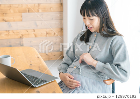 リビングで在宅ワークをする妊婦 128970192