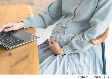 リビングで在宅ワークをする妊婦 リビングで在宅ワークをする妊婦 128970194
