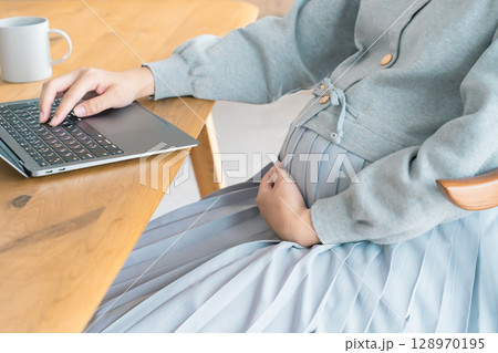リビングで在宅ワークをする妊婦 リビングで在宅ワークをする妊婦 128970195