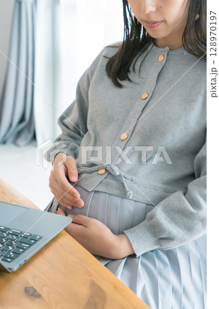 リビングで在宅ワークをする妊婦 128970197