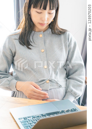 リビングで在宅ワークをする妊婦 リビングで在宅ワークをする妊婦 128970203