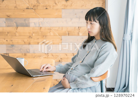 リビングで在宅ワークをする妊婦 リビングで在宅ワークをする妊婦 128970224