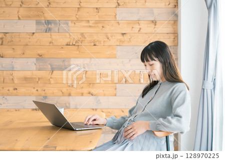 リビングで在宅ワークをする妊婦 リビングで在宅ワークをする妊婦 128970225