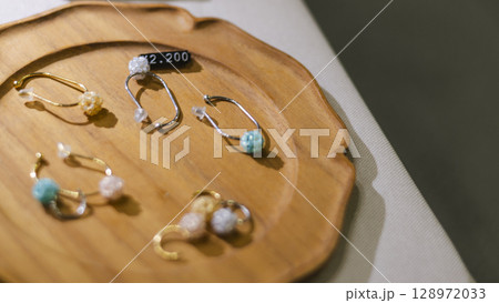 木皿に陳列されたピアスの展示販売　 128972033