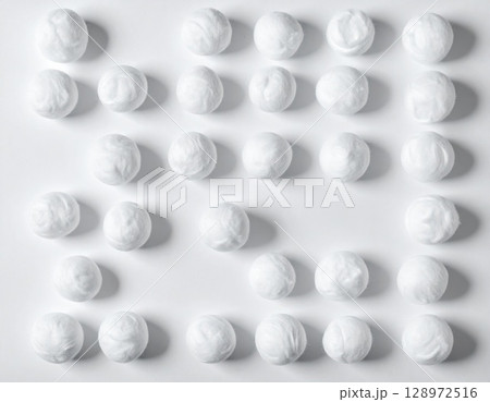 Geometric Arrangement of White Cotton Balls Creating a Clean Grid Pattern on White 128972516