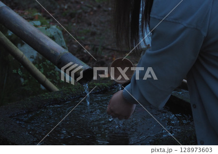 手水舎で手を洗う女性 128973603
