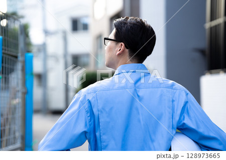 作業着の男性　現場　後ろ姿 128973665