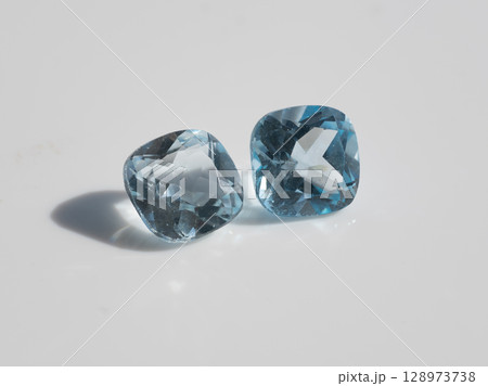 Stunning Natural Blue Topaz Gemstones Pair, Radiant Cushion Cut, Sparkling Crystal Clear, Light Azure Color, Jewelry Making, Isolated Studio Shot. Stunning Natural Blue Topaz Gemstones Pair, Radiant Cushion Cut, Sparkling Crystal Clear, Light Azure Color, Jewelry Making, Isolated Studio Shot. 128973738