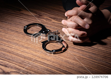 犯罪者　手錠　手元 128974706