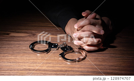 犯罪者　手錠　手元 128974707