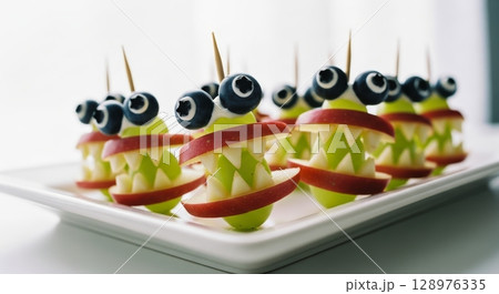 Creative monster fruit skewers with apple jaws and blueberry eyes for a fun snack 128976335