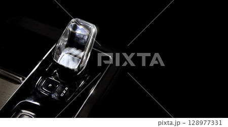 EV Car gear. Close up of modern automatic car gear shifters in luxury vehicle interiors. Feature sleek ergonomic designs and advanced car transmission controls for premium driving experience. EV gear EV Car gear. Close up of modern automatic car gear shifters in luxury vehicle interiors. Feature sleek ergonomic designs and advanced car transmission controls for premium driving experience. EV gear 128977331