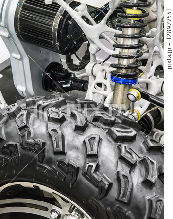 Details of an off-road vehicle suspension system highlighting the tire, shock absorber, and motor components 128977551