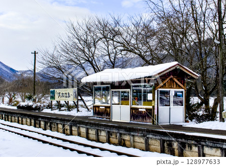 田舎の駅ホームと待合室屋根に雪が積もっている風景 128977633