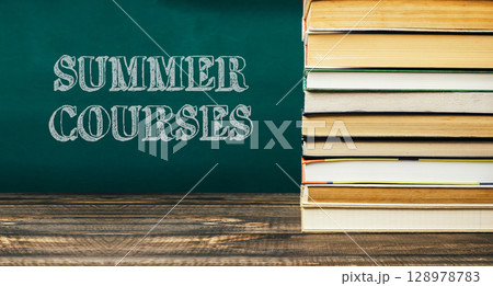 A stack of books with the words Summer Courses written on a chalkboard 128978783