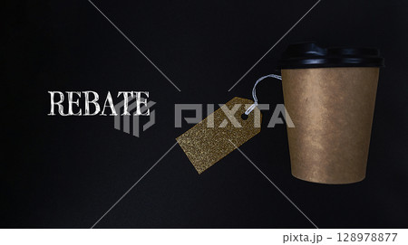 Coffee cup with a gold tag hanging from it that says Rebat 128978877