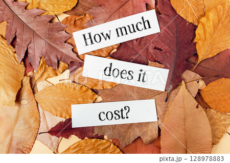 Pile of autumn leaves with a white paper that says How much does it cost Pile of autumn leaves with a white paper that says How much does it cost 128978883