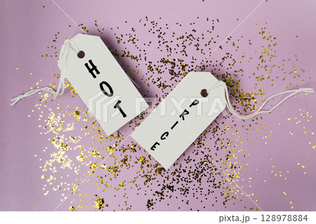 Two tags with the word HOT price on them are on top of a pile of glitter Two tags with the word HOT price on them are on top of a pile of glitter 128978884