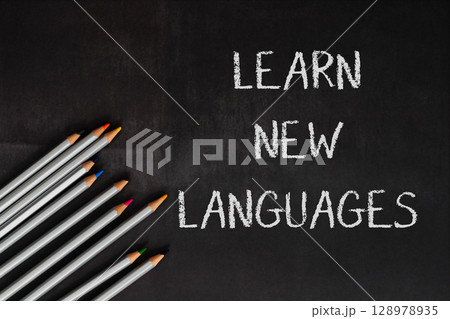 A blackboard with the words learn new languages written on it A blackboard with the words learn new languages written on it 128978935