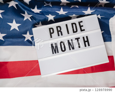 Pride month is written on a white sign that is placed on top of a red, white Pride month is written on a white sign that is placed on top of a red, white 128978990