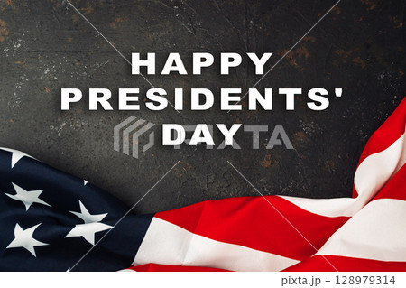 The flag is draped over a dark background, creating a sense of patriotism The flag is draped over a dark background, creating a sense of patriotism 128979314