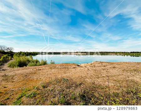 A beautiful lake with a clear blue sky above it 128979863