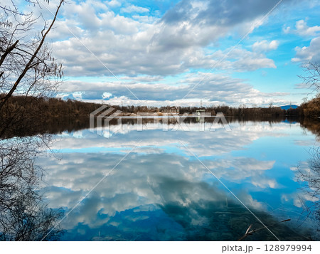 A lake with a cloudy sky in the background 128979994