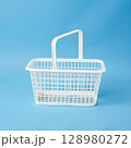 White basket with a handle sits on a blue background 128980272