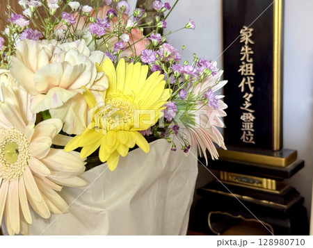 位牌の前に黄色い花などたくさんの供花 位牌の前に黄色い花などたくさんの供花 128980710