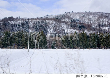 電車の中から眺める山や田畑の雪景色が美しい 電車の中から眺める山や田畑の雪景色が美しい 128980728