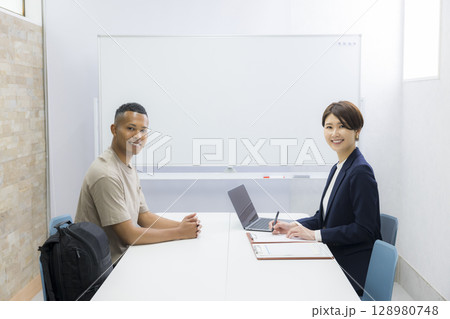 外国人の男性に説明をする女性 外国人の男性に説明をする女性 128980748